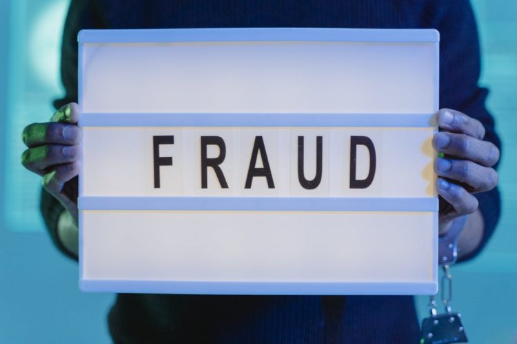 Photo by Tima Miroshnichenko from Pexels: https://www.pexels.com/photo/a-person-with-handcuffs-holding-a-sign-that-says-fraud-6266506/