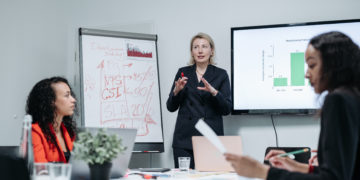 Photo by Pavel Danilyuk from Pexels: https://www.pexels.com/photo/woman-in-black-blazer-presenting-in-a-meeting-8424484/