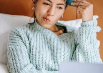 Source: https://www.pexels.com/photo/pensive-ethnic-shopper-with-debit-card-and-laptop-on-bed-6347709/
