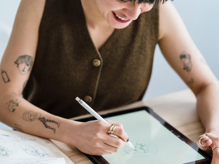 Photo by Michael Burrows from Pexels: https://www.pexels.com/photo/smiling-woman-drawing-on-graphic-tablet-with-pencil-at-table-7147701/