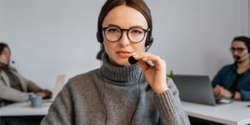 Photo by MART PRODUCTION from Pexels: https://www.pexels.com/photo/photo-of-a-woman-with-black-framed-eyeglasses-touching-a-microphone-7709207/