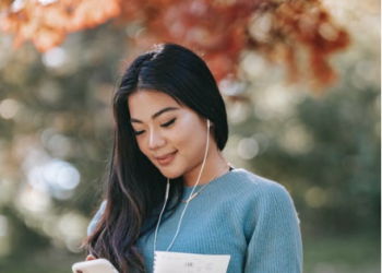 Image source: https://www.pexels.com/photo/young-cheerful-woman-listening-to-audio-book-using-smartphone-in-park-5965925/