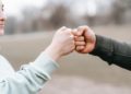 Photo by Andres  Ayrton: https://www.pexels.com/photo/man-and-happy-woman-greeting-each-other-with-fist-bump-6551298/