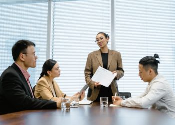 Photo by MART PRODUCTION: https://www.pexels.com/photo/woman-standing-up-in-front-of-colleagues-during-meeting-7644066/
