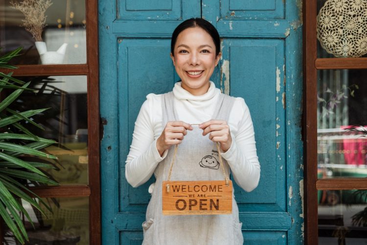 Photo by Ketut Subiyanto: https://www.pexels.com/photo/ethnic-female-cafe-owner-showing-welcome-we-are-open-inscription-4473398/