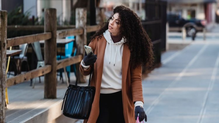 Photo by Tim Douglas : https://www.pexels.com/photo/attentive-female-carrying-shopping-bags-while-walking-with-smartphone-6567663/