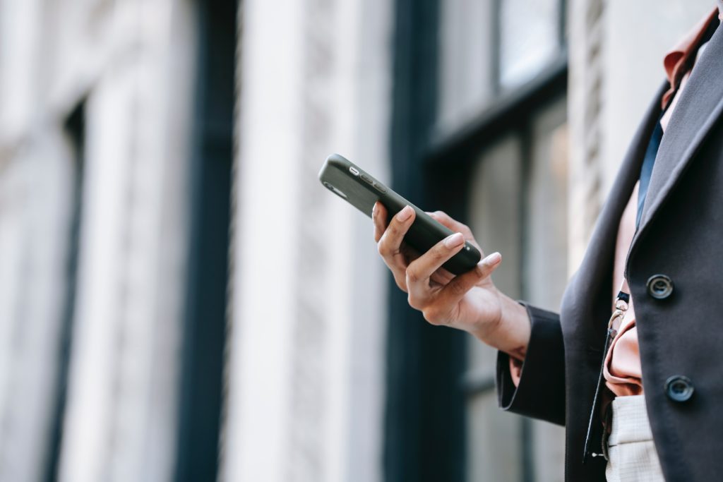 Photo by Ono Kosuki: https://www.pexels.com/photo/crop-businesswoman-messaging-on-smartphone-while-standing-near-building-on-street-5999786/