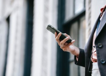 Photo by Ono Kosuki: https://www.pexels.com/photo/crop-businesswoman-messaging-on-smartphone-while-standing-near-building-on-street-5999786/