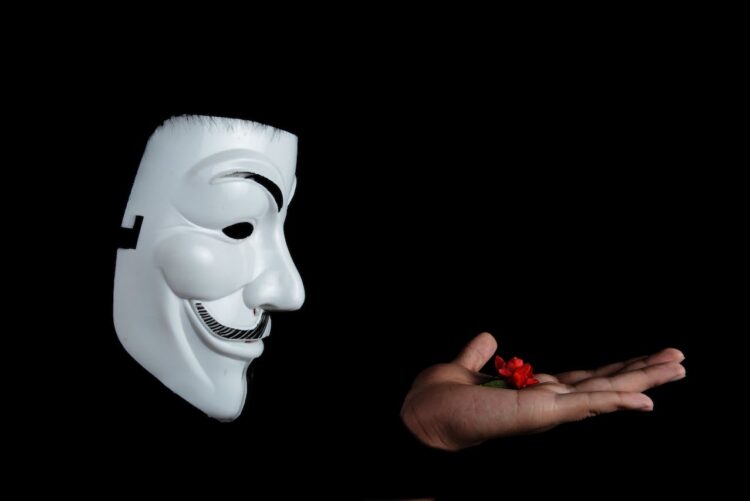 Photo by Pixabay: https://www.pexels.com/photo/guy-fawkes-mask-and-red-flower-on-hand-38275/