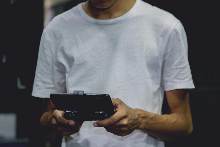 Photo by Nino Souza: https://www.pexels.com/photo/a-smartphone-game-controller-on-a-person-s-hand-2883029/