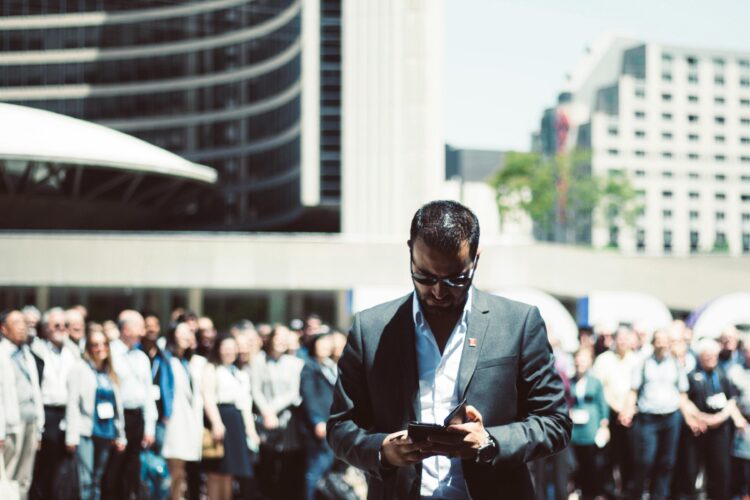 Photo by Yama Saighani: https://www.pexels.com/photo/selective-focus-photography-of-man-holding-smartphone-while-standing-near-people-624367/