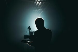 Photo by Kyle Loftus: https://www.pexels.com/photo/silhouette-of-man-standing-in-front-of-microphone-3379934/