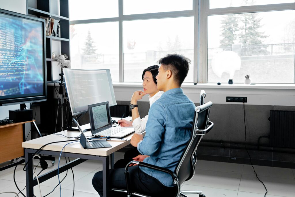 Photo by Mikhail Nilov: https://www.pexels.com/photo/men-sitting-on-a-swivel-chair-having-a-discussion-while-looking-at-the-board-7988748/ Japan, computer, office, work