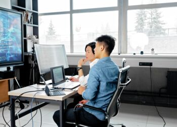 Photo by Mikhail Nilov: https://www.pexels.com/photo/men-sitting-on-a-swivel-chair-having-a-discussion-while-looking-at-the-board-7988748/ Japan, computer, office, work
