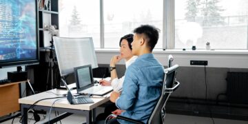 Photo by Mikhail Nilov: https://www.pexels.com/photo/men-sitting-on-a-swivel-chair-having-a-discussion-while-looking-at-the-board-7988748/ Japan, computer, office, work
