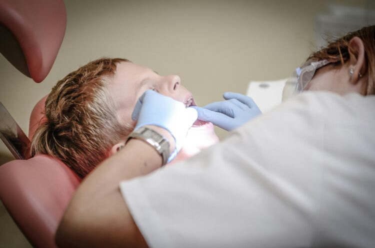 Photo by Pixabay: https://www.pexels.com/photo/dentist-woman-wearing-white-gloves-and-white-scrubsuit-checking-boy-s-teeth-52527/