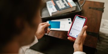 Photo by RDNE Stock project: https://www.pexels.com/photo/person-holding-blue-card-and-a-cellphone-7821552/